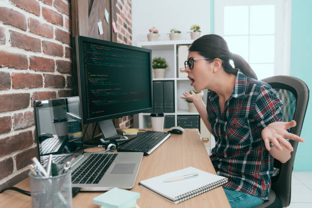 stunned beautiful programmer woman looking at computer feeling dumbfounded because her online system was attacked from hacker.